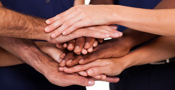 Group of people joined with their hands stacked